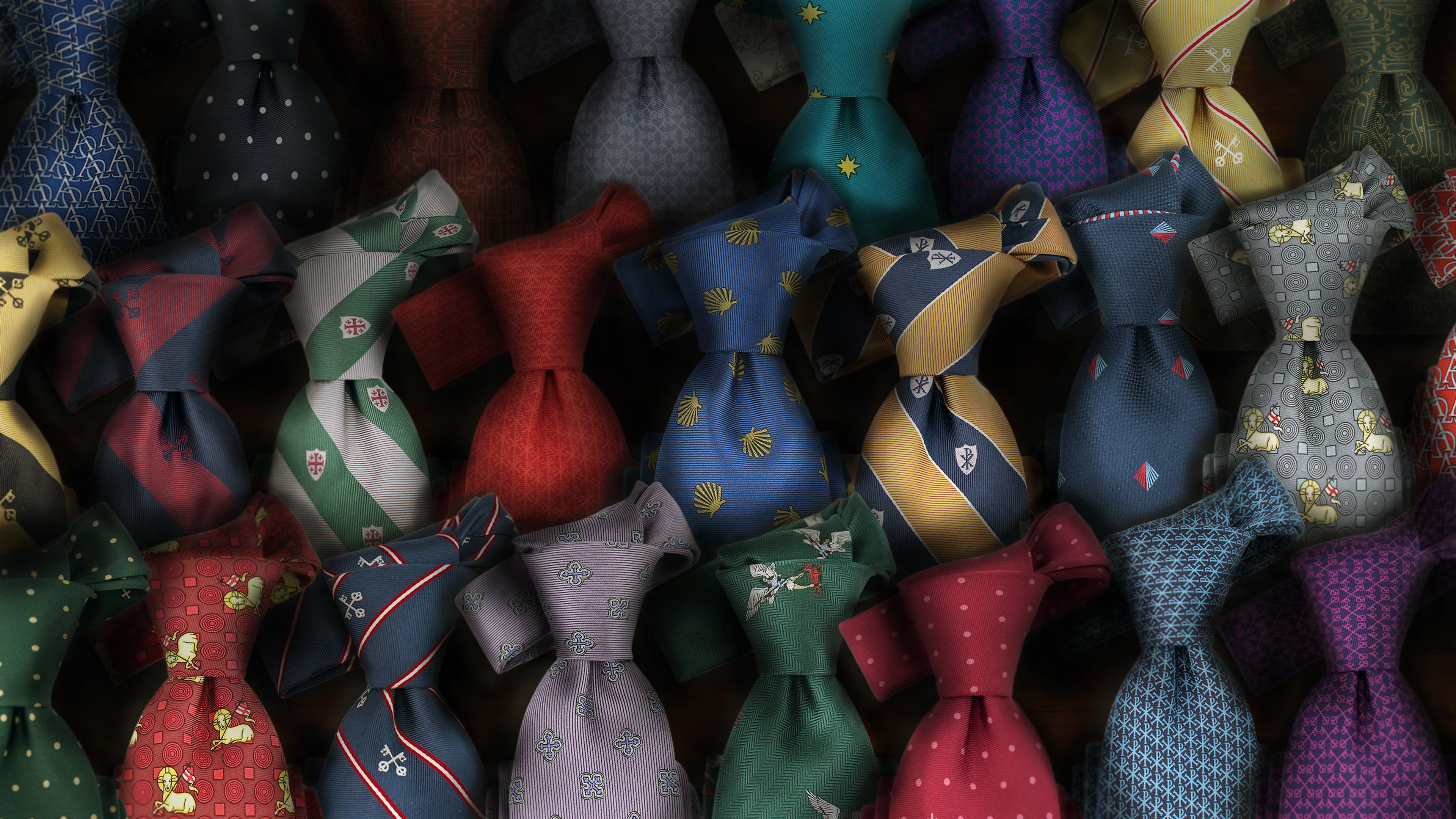 Collection of premium Catholic men's silk neckties displayed together, featuring faith-inspired designs including St. Michael, Keys of St. Peter, Divine Mercy, and Byzantine Cross motifs for religious and formal wear.