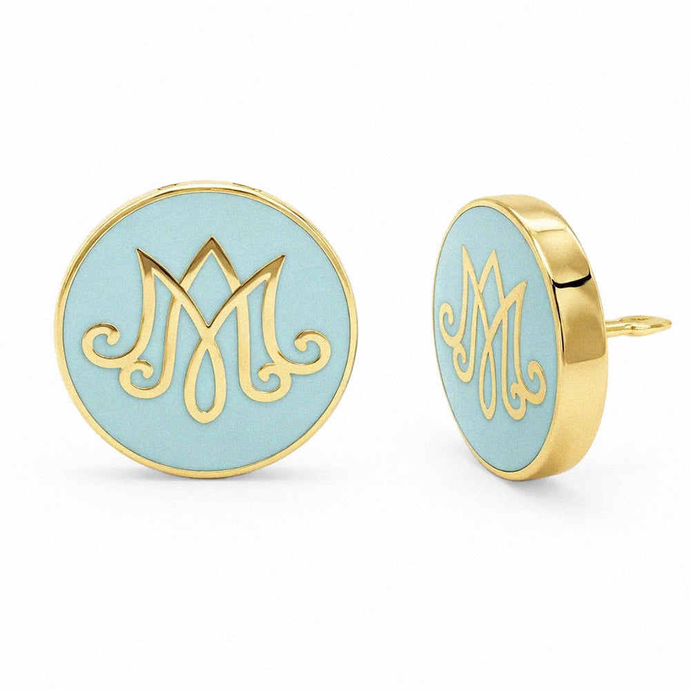 Pair of lapel pins with gold monogram design on a light blue background