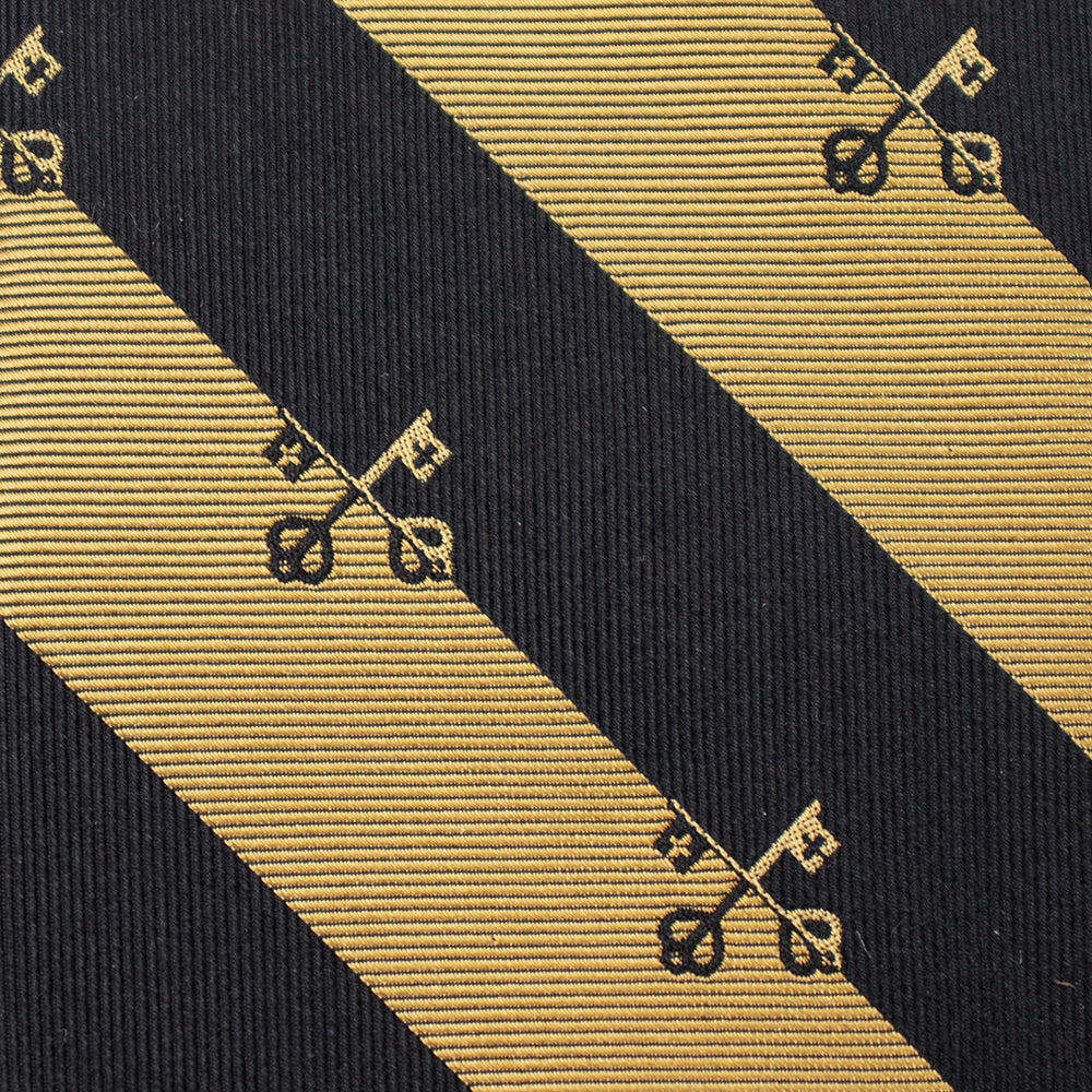 Close-up of a black and gold striped tie with decorative patterns. Catholic men's gift.