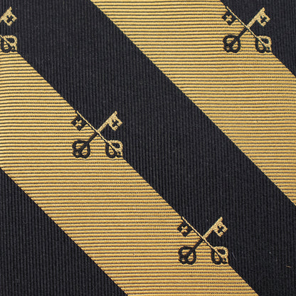 Close-up of a black and gold striped tie with decorative patterns. Catholic men's gift.