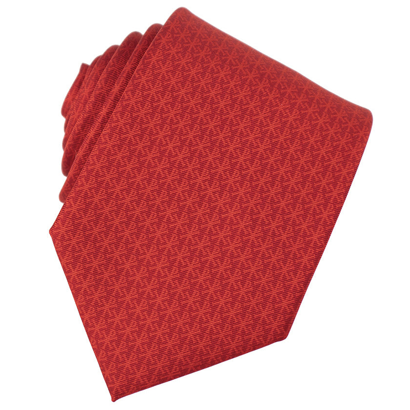 Folded red patterned tie on a white background