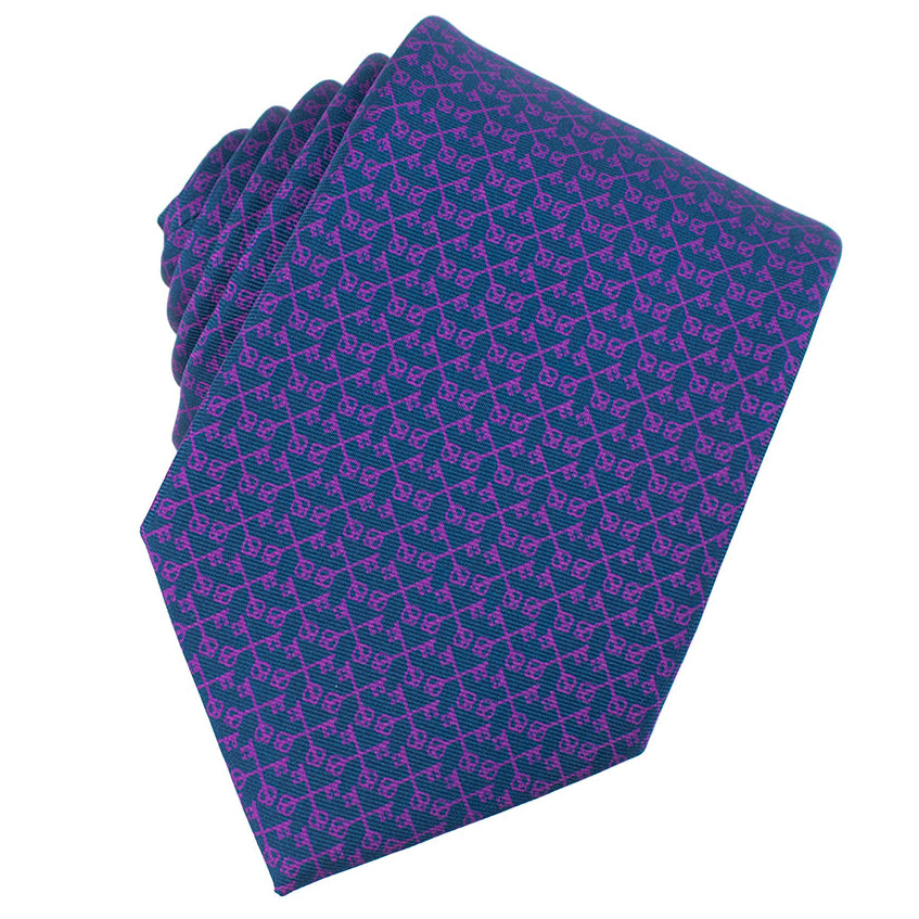 Folded purple tie with a pattern on a white background. Catholic Men's Shop silk necktie.