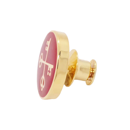 Gold and red lapel pin on a white background